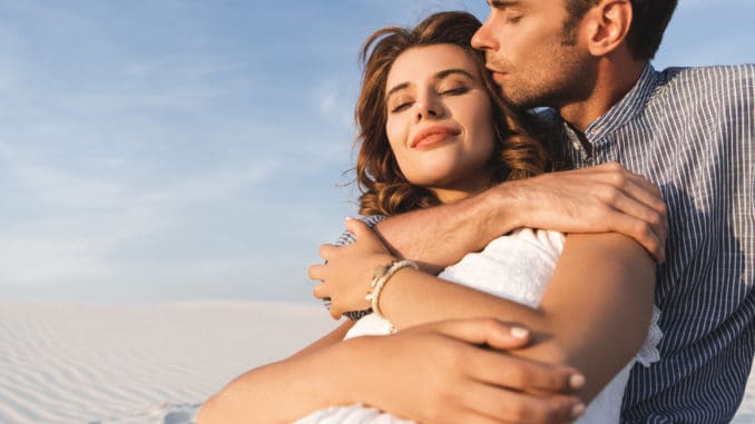 Smiling young couple hugging on beach