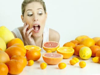 Portrait of young woman with citrus fruit