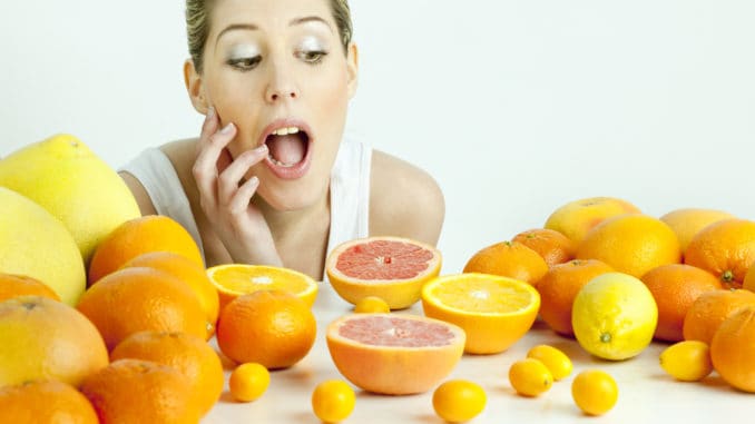 Portrait of young woman with citrus fruit