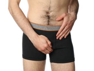 Man holding his groin, isolated on background. Men`s health