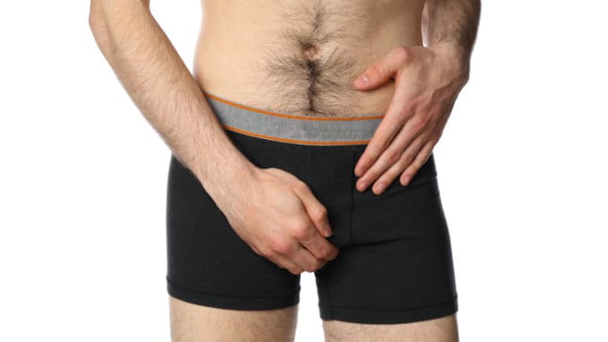 Man holding his groin, isolated on background. Men`s health