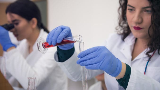 Group of Laboratory scientists working at lab with test tubes,