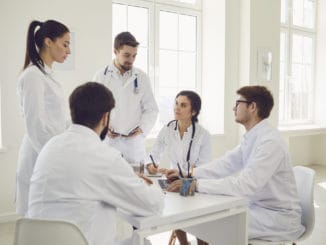 Group of doctors talking sitting at a table in the office of the hospital.