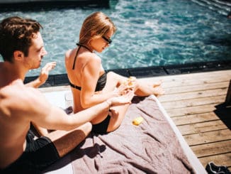 Young hot couple resting at swimpool.