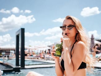 Young hot woman resting at swimpool. relaxed girl drinking cocktail and enjoy her time in resort spa place ouside