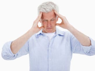 Tired man having a headache against a white background