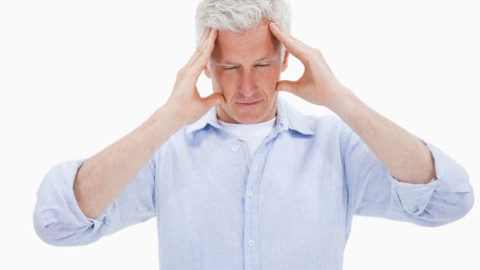 Tired man having a headache against a white background