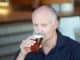 Middle aged man drinking beer from a glass in a pub, a bar or a restaurant