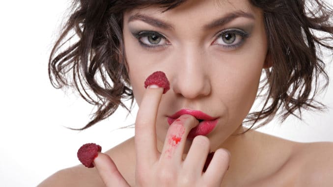 woman eating raspberry