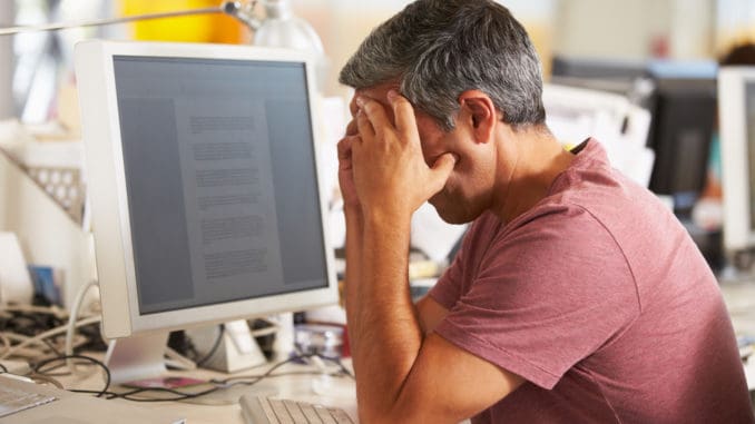 Stressed Man Working At Desk