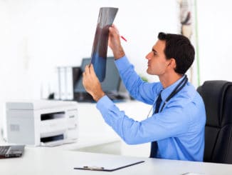Male doctor analyzing CT scan in office