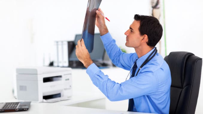 dreamstime_m_30689493 Male doctor analyzing CT scan in office