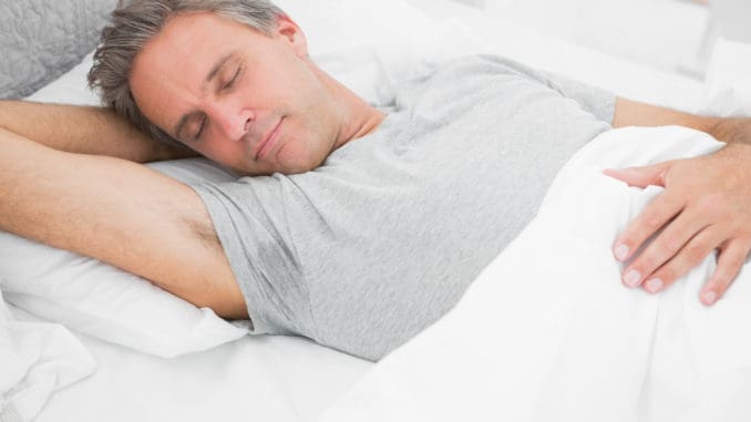 Man sleeping peacefully at home in his bed