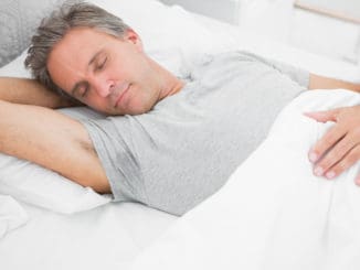 Man sleeping peacefully at home in his bed