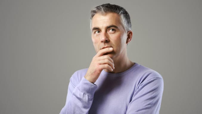 Portrait of casual man thinking and looking up