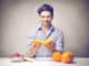 Young man holding an orange to do an orange juice