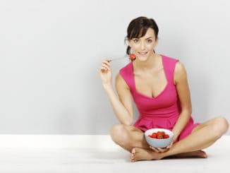 Young woman eating fresh strawberries