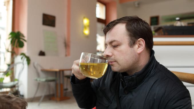 Man drinks green tea in a cafe