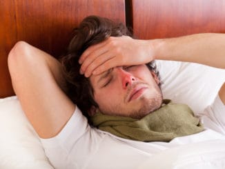 Young man having a flu lying in bed