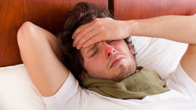 Young man having a flu lying in bed