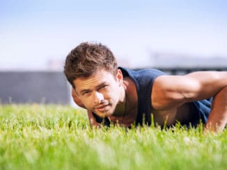 Healthy young man doing pushups outdoors