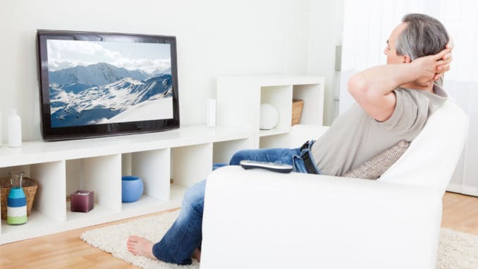 Portrait of a mature man watching tv at home