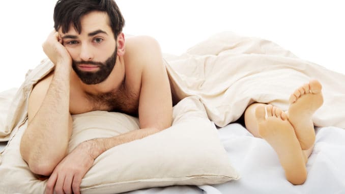 Young handsome depressed men in bed.