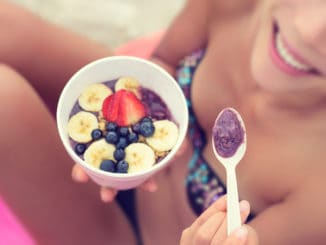 girl eating healthy food on beach