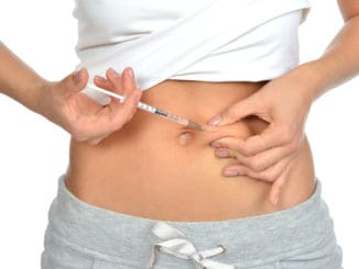 Diabetes patient insulin shot by syringe with dose of lantus, subcutaneous abdomen vaccination isolated on a white background