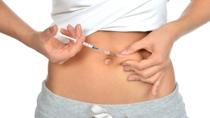 Diabetes patient insulin shot by syringe with dose of lantus, subcutaneous abdomen vaccination isolated on a white background