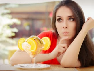 Beautiful girl thinking about eating a sweet treat