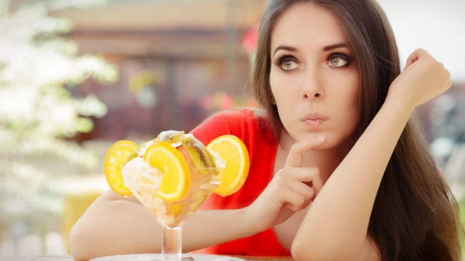 Beautiful girl thinking about eating a sweet treat