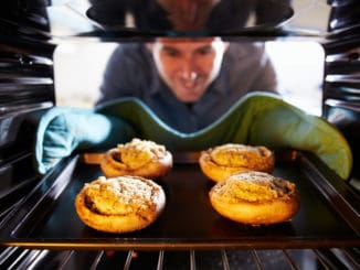 Man Putting Stuffed Mushrooms Into Oven To Cook