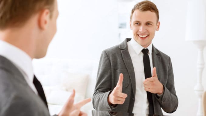 Man looking in mirror and pointing on himself You are winner. Smiling man looking in mirror and pointing on himself with help of his index fingers.