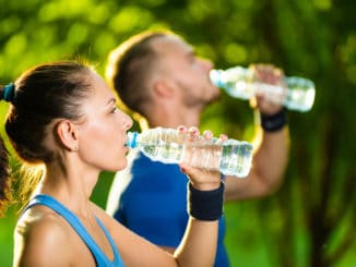 Man and women drinking water from bottle after fitness sport exercise.