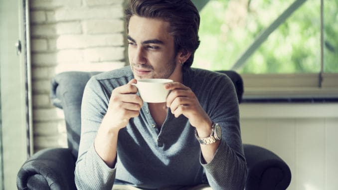 Young man drinking coffee in cafe