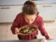 a woman is standing, breathing in the rich, earthy smell of dried mushrooms as she stands in a kitchen.