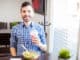 Portrait of a young Latin man eating some healthy food and enjoying a smoothie alone at a restaurant