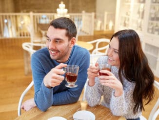People, communication and dating concept - happy couple drinking tea at cafe or restaurant