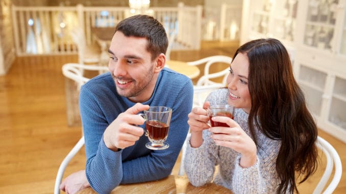 People, communication and dating concept - happy couple drinking tea at cafe or restaurant