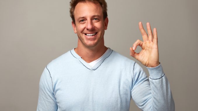 Happy excited lucky man over gray wall background