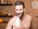 Muscular man drinking milk from the bottle on the kitchen