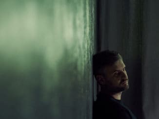 Lonely man sitting alone in gloomy room