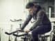 Attractive young man exercise in gym: spinning, exercising on stationary bike