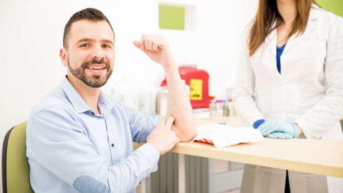 Portrait of a handsome young Hispanic men right after taking a blood test in a laboratory