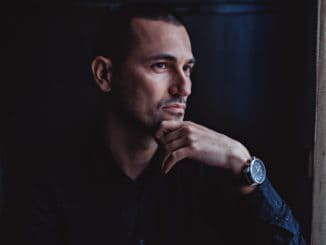 Handsome man looking through window and thinking