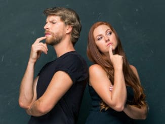 Young love Couple standing together at dark studio and remembering and thinking about something