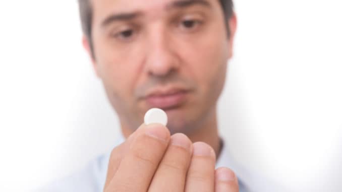 Head of sick man eating medicine pill