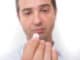 Head of sick man eating medicine pill