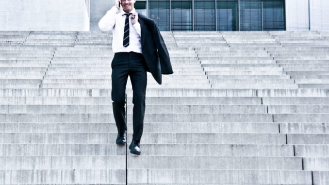 Corporate Man With Cellular Phone Descending On Company Stairs